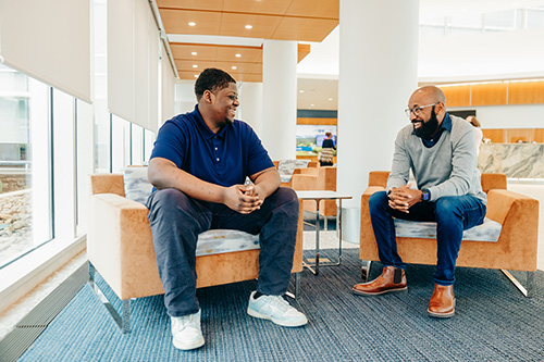 two coworkers talking and laughing onsite.
